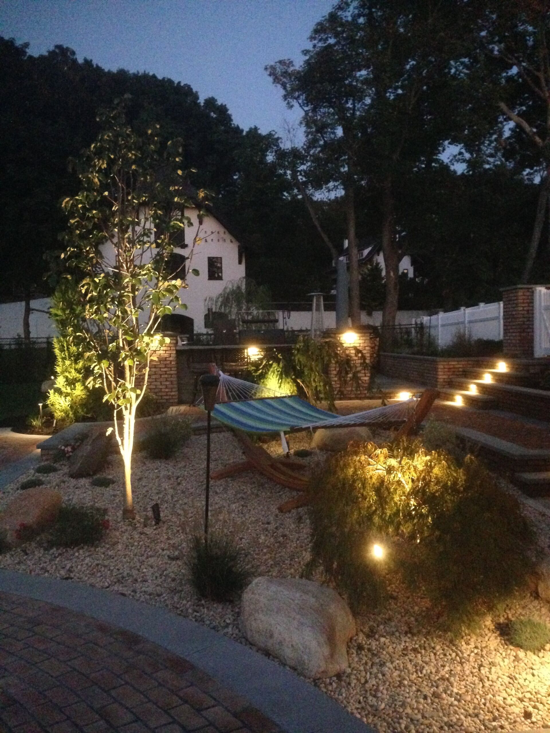 Layered outdoor lighting across a landscaped yard