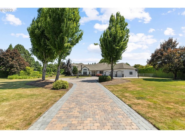 paver-drive Long paver driveway connecting a landscaped yard to the home