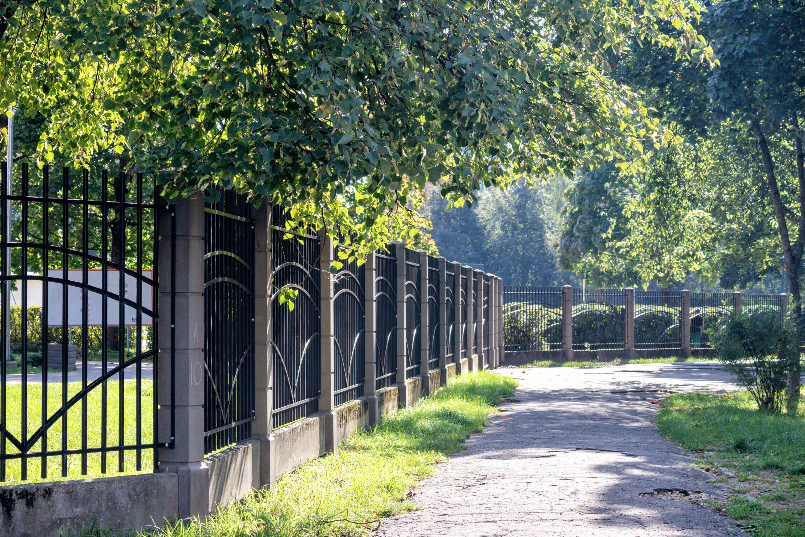 pedestrian-path-green-trees-forged-metal-fence-side (1) Fence beside a landscaped pedestrian path