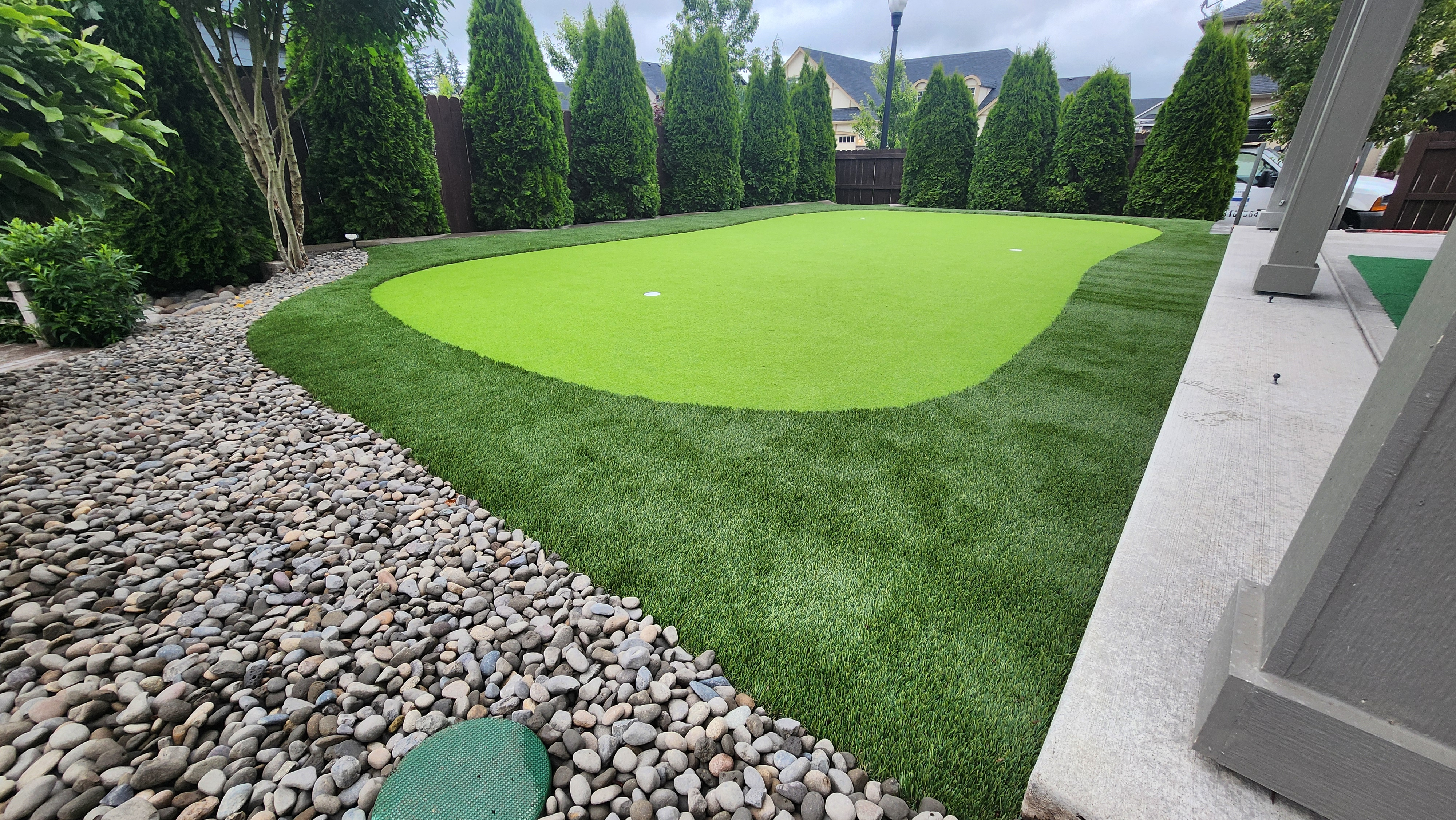 Lawn Mowing first time Backyard putting green with river rock and landscaped borders